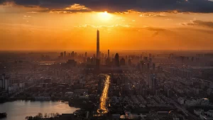 Vista aérea de uma cidade ao pôr do sol destacando o urbanismo e arquitetura moderna. Mercados Emergentes